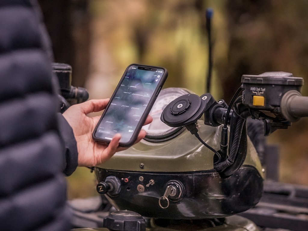 bar clamp attached to motorbike while using smartphone to navigate