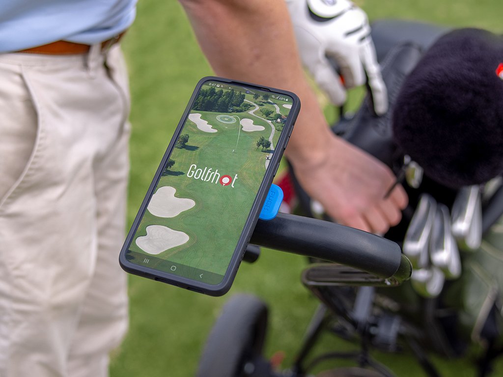 golfer grabs clubs while golfshot app loads on phone mount